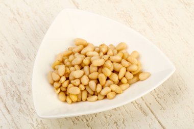 Sedir fındık yığın içinde kase ahşap arka plan üzerinde