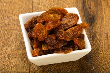 Ahşap arka plan üzerinde kase kuru kuru üzüm