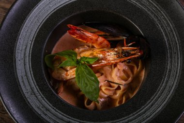 Fesleğen yaprakları ile deniz ürünleri makarna