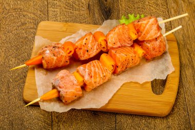 Pişmeye hazır baharatlı çiğ somon şişi.