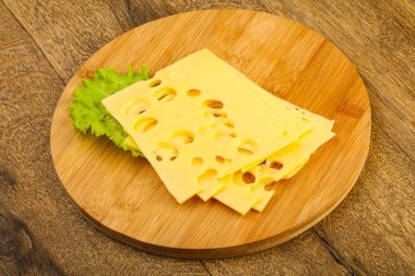 Ahşap arka plan üzerinde dilimlenmiş peynir salata yaprakları