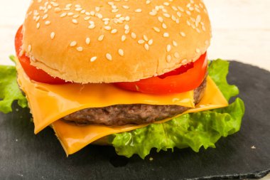 Burger peynir, domates, salata yaprakları ile