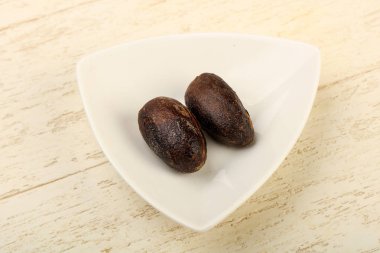 Culinare için iki Nutmegs ahşap arka plan üzerinde kullanın