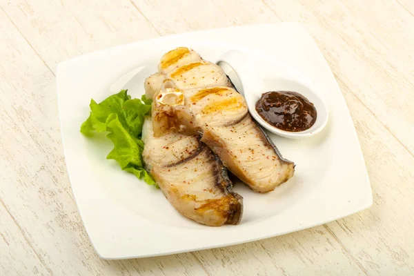 Grilled shark steak with pepper sauce and salad leaves