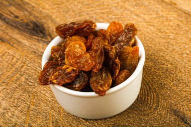 Ahşap arka plan üzerinde kase kuru kuru üzüm