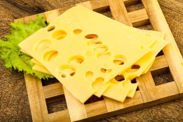 Ahşap arka plan üzerinde dilimlenmiş peynir salata yaprakları