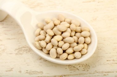 Kase ahşap arka plan üzerinde beyaz kuru fasulye