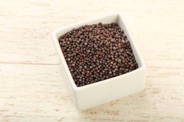 Kase ahşap arka plan üzerinde siyah hardal tohumu yığın