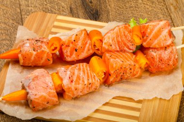 Pişmeye hazır baharatlı çiğ somon şişi.