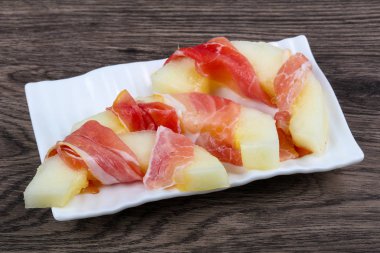 Ahşap arka plan üzerinde prosciutto ile kavun