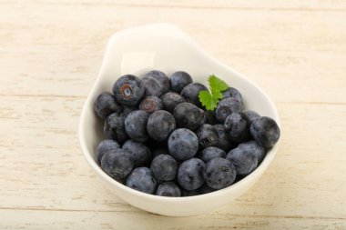 Kase ahşap arka plan üzerinde yabanmersini