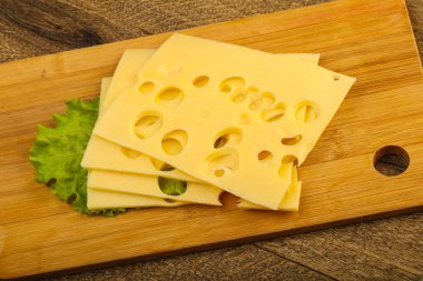 Ahşap arka plan üzerinde dilimlenmiş peynir salata yaprakları