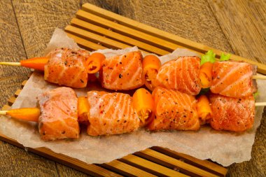 Pişmeye hazır baharatlı çiğ somon şişi.