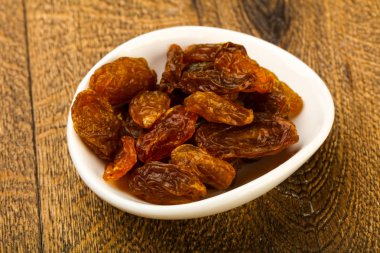 Ahşap arka plan üzerinde kase kuru kuru üzüm