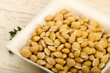 Kase ahşap arka plan üzerinde çiğ beyaz fasulye