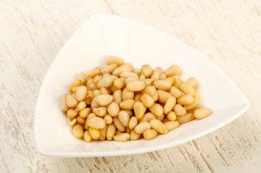 Sedir fındık yığın içinde kase ahşap arka plan üzerinde