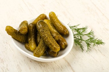 Ahşap arka plan üzerinde kaseye Picled salatalık