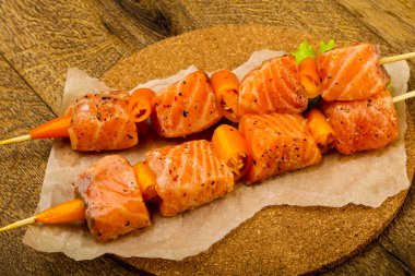 Pişmeye hazır baharatlı çiğ somon şişi.