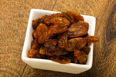 Ahşap arka plan üzerinde kase kuru kuru üzüm