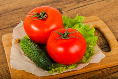 Salatalık ve domates salatası ile ahşap arka plan üzerinde bırakır