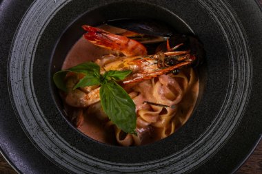 Fesleğen yaprakları ile deniz ürünleri makarna