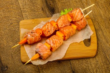 Pişmeye hazır baharatlı çiğ somon şişi.