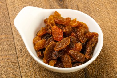 Ahşap arka plan üzerinde kase kuru kuru üzüm