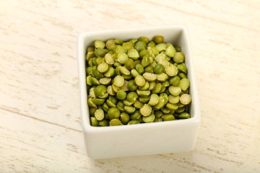 Yeşil bezelye kasede ahşap arka plan üzerinde kazık.