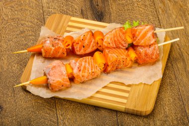 Pişmeye hazır baharatlı çiğ somon şişi.