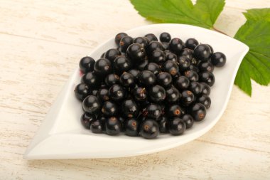 Olgun siyah kuş üzümü ile yaprak kase