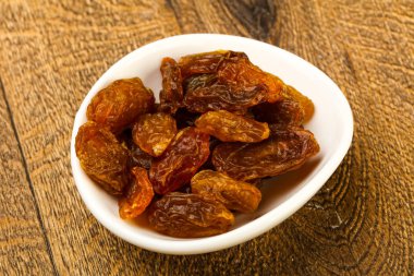 Ahşap arka plan üzerinde kase kuru kuru üzüm