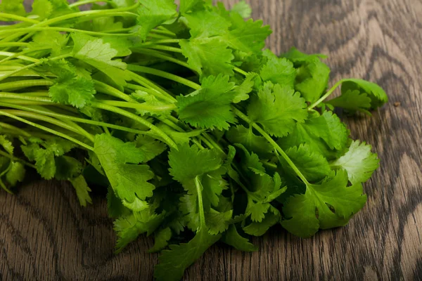 Coriander leaves over wooden background
