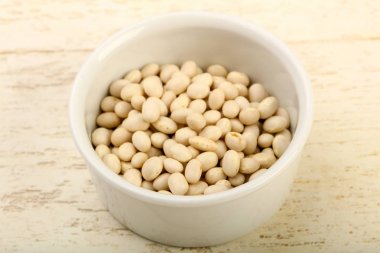 Kase ahşap arka plan üzerinde beyaz kuru fasulye