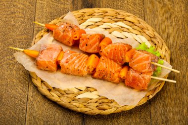 Pişmeye hazır baharatlı çiğ somon şişi.