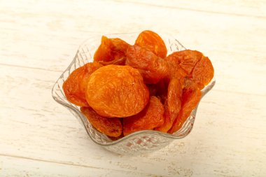 Kuru Kayısı yığın içinde kase ahşap arka plan üzerinde