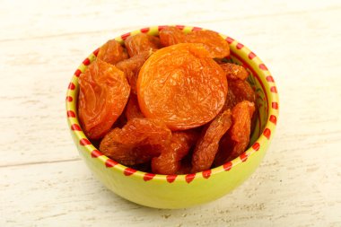 Kuru Kayısı yığın içinde kase ahşap arka plan üzerinde