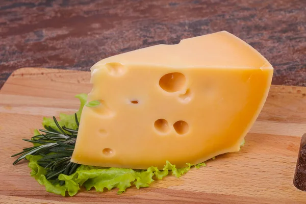 Maasdam-Käse im Brett serviert Salatblätter — Stockfoto