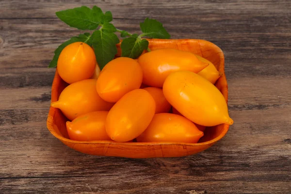 Yellow tomato heap in the wooden bowl — Stock Photo, Image