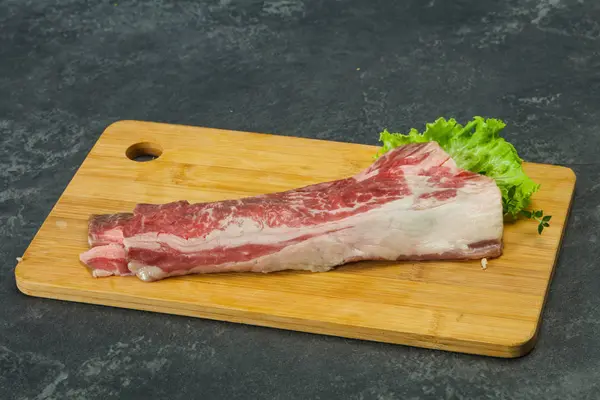 Pancetta di manzo crudo su tavola di legno — Foto Stock