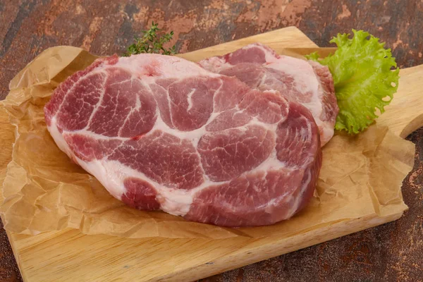 Raw pork steak over wooden board — Stock Photo, Image