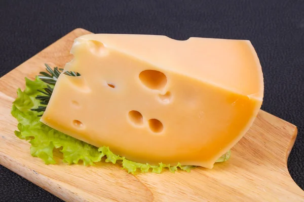 Maasdam-Käse im Brett serviert Salatblätter — Stockfoto