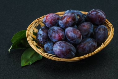 Olgun erik yığını sepetin içinde yapraklarla