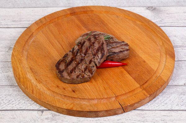Grilled Fillet Mignon with rosemary and chili pepper over the wooden background
