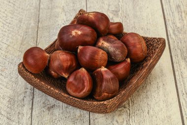 Kestane yığını ahşap arka planda.