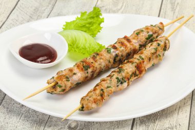 İnce kıymalı domuz şişi kebap ve bbq sosu.