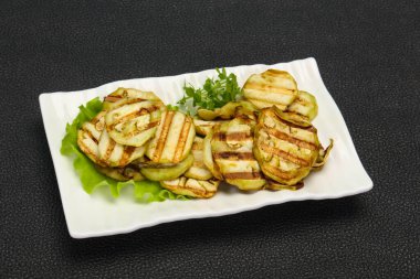 Izgara patlıcan dilimleri fesleğen ve salata yaprakları servis edilir.