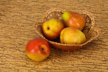 Tahta sepetteki olgun armut yığını.