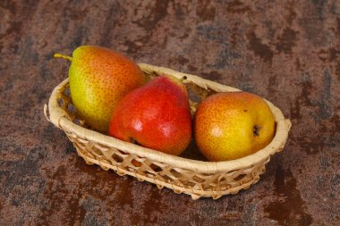 Tahta sepetteki olgun armut yığını.