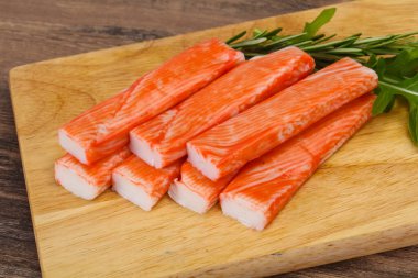 Ahşap tahtanın üzerinde yengeç çubuğu surimi