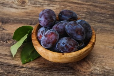 Olgun erik yığını sepetin içinde yapraklarla